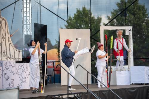 Aktor przebrany za Koziołka Matołka i inne postaci na scenie podczas wystepu. Aktorzy mają narty.